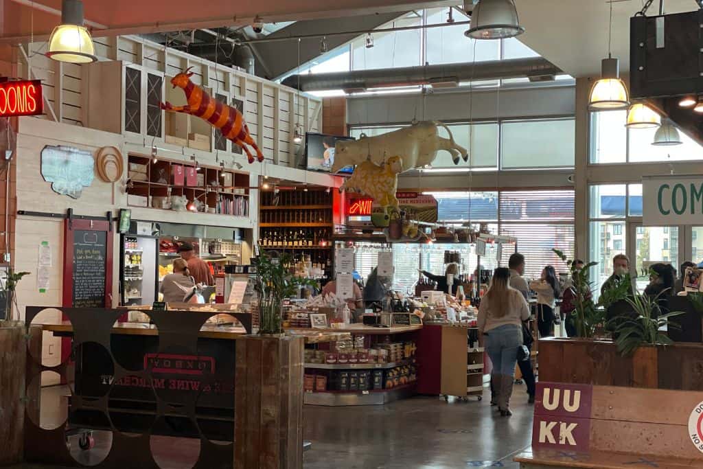 People at the bustling Oxbow Market browsing cheese and wine