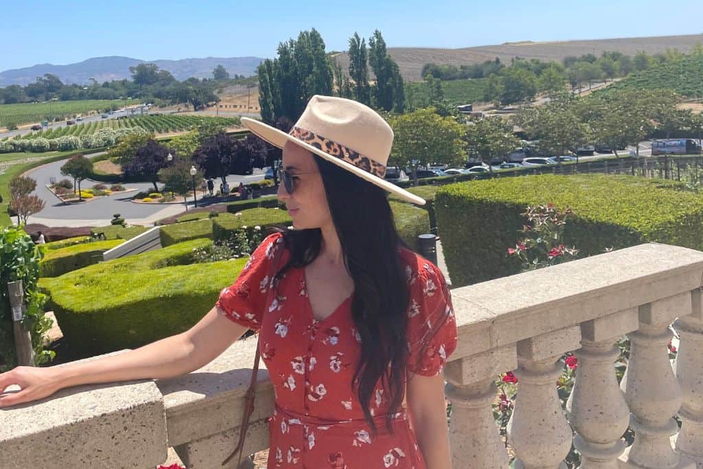 A woman standing on a balcony overlooking Napa's pituresque vineyards