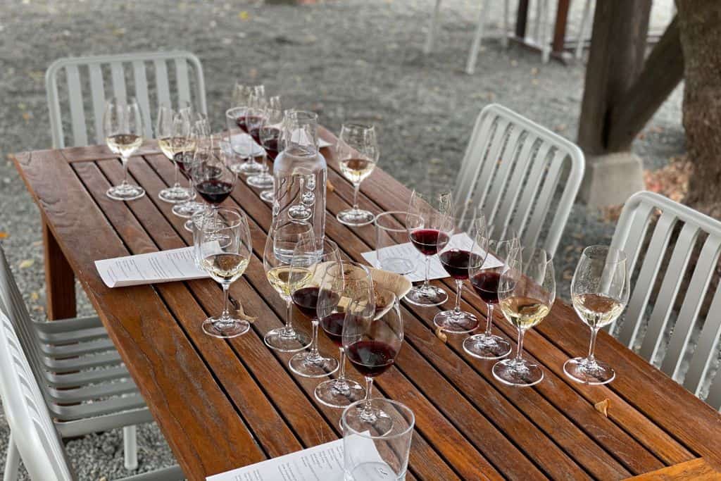 a wooden table set for a four person wine tasting